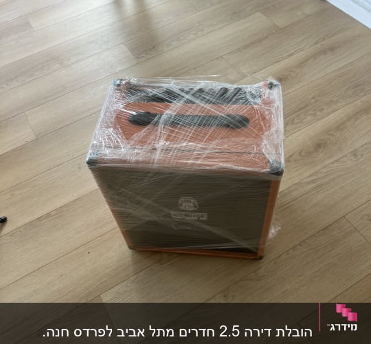 ארגז עטוף בניילון על רצפת עץ